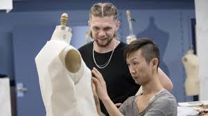 Brandon Kee working on a mannequin in a fashion studio alongside another designer.