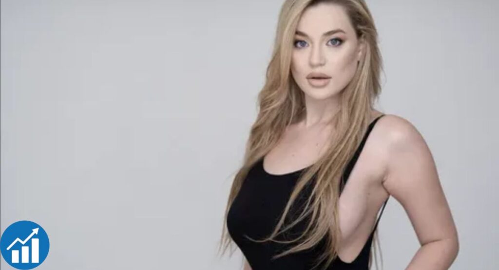 Blake Blossom wearing a black sleeveless top in front of a light gray background