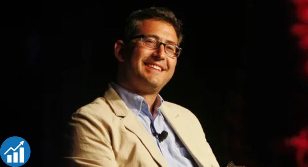 Sam Seder speaking into a microphone during a podcast recording in a studio