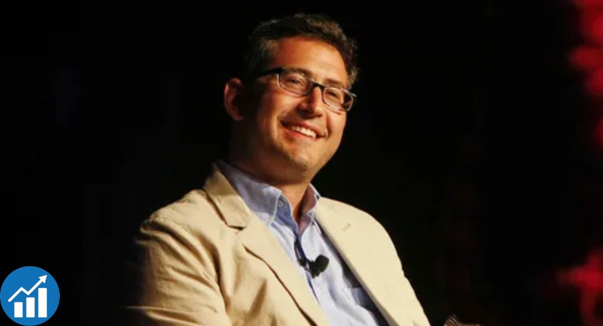 Sam Seder speaking into a microphone during a podcast recording in a studio
