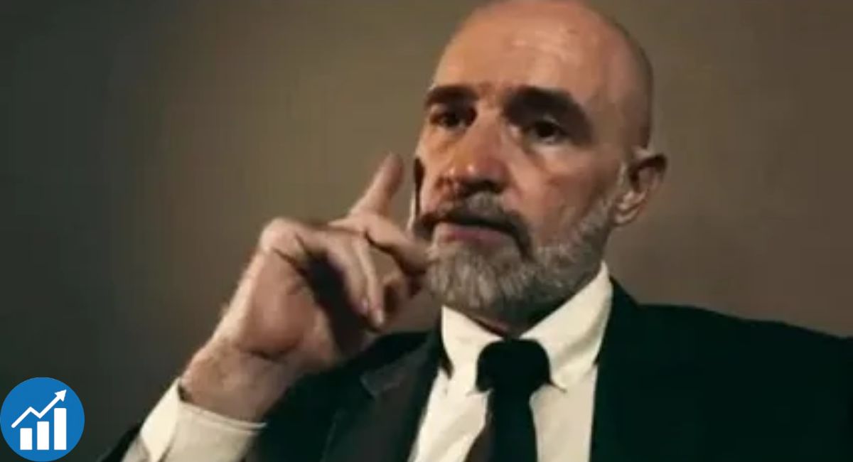 Shahid Bolsen speaking in a suit, making a point during an interview.