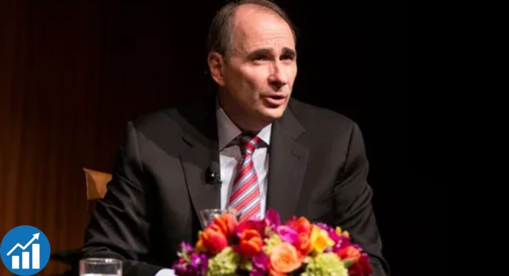 David Axelrod speaking at a political event in a suit and tie